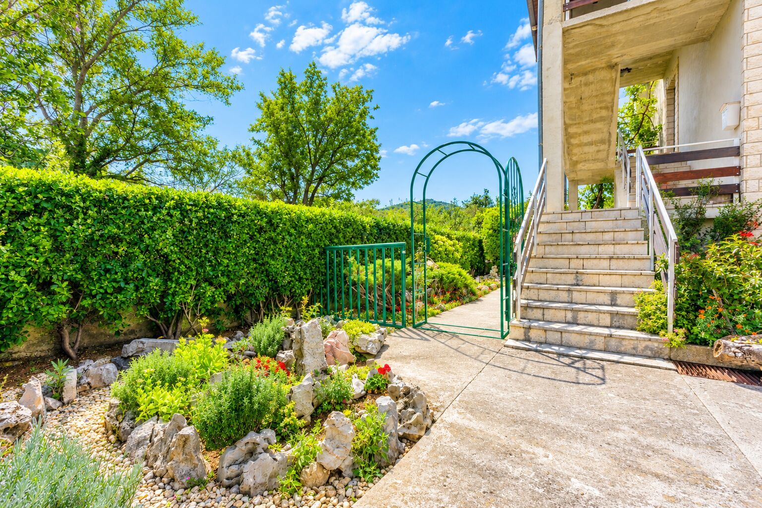 Ein angelegter Garten mit einem Kiesweg, der zu einer Treppe führt.
