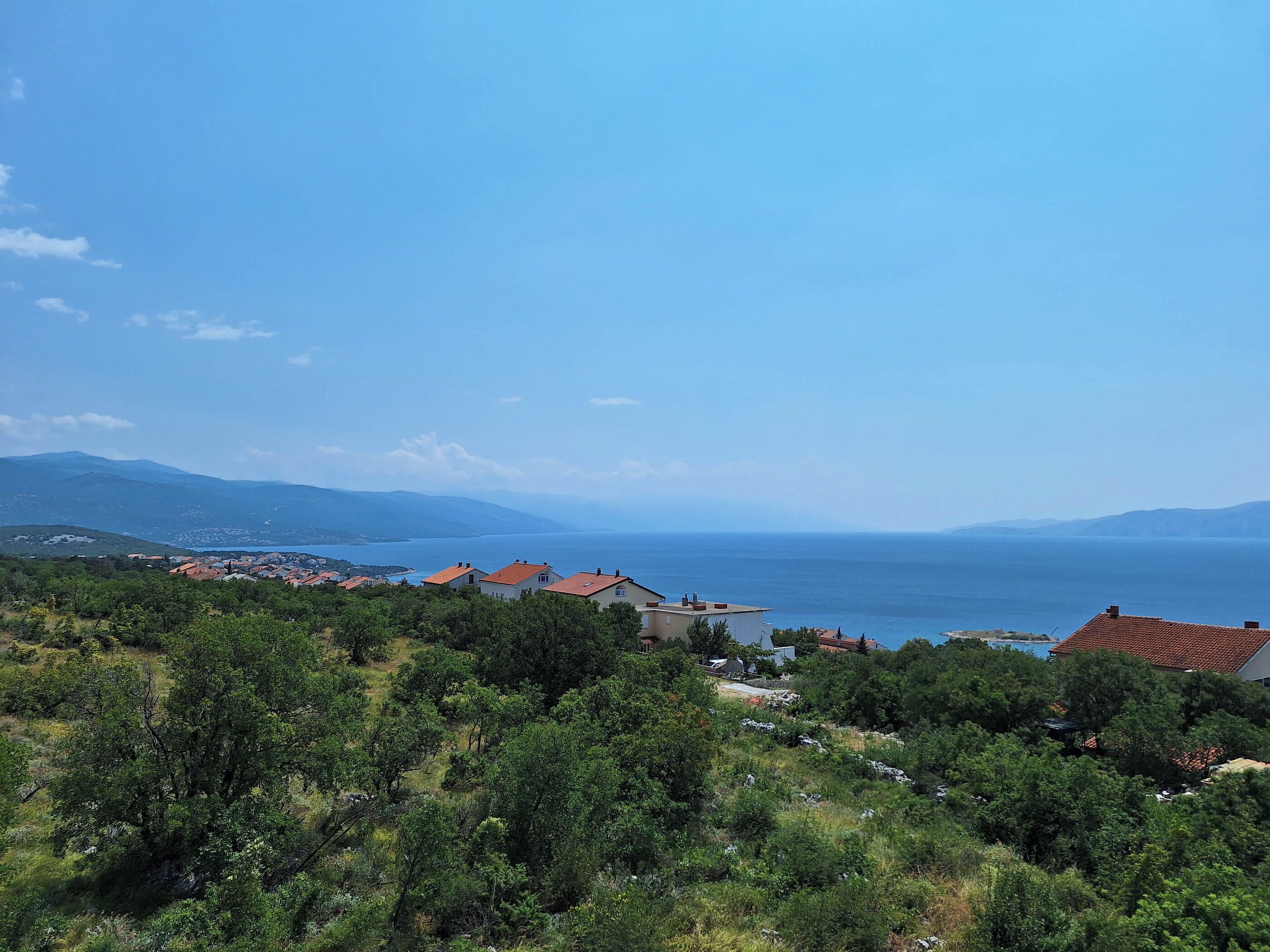A coastal landscape with houses and a view of the sea.