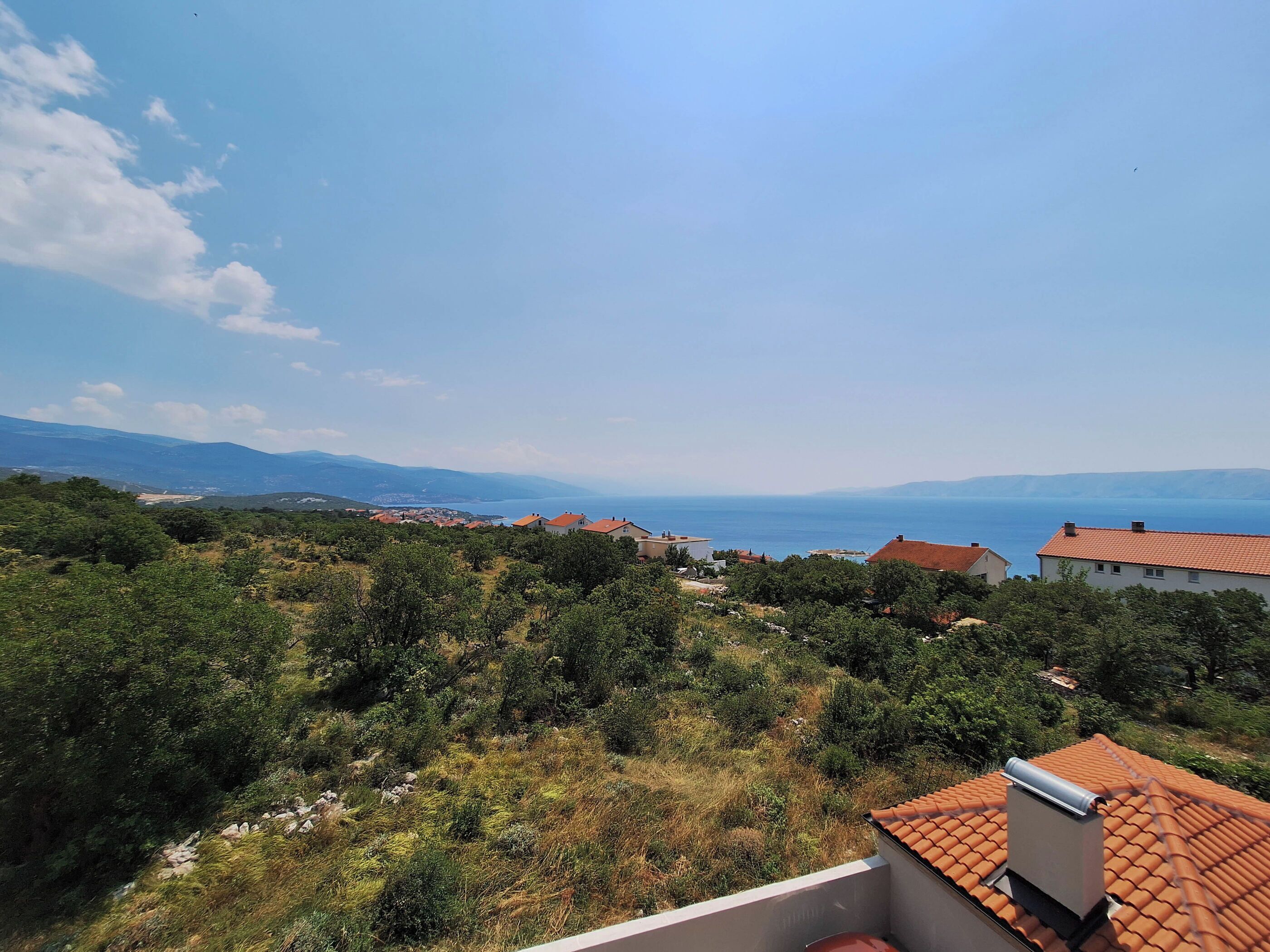 A coastal view with houses and greenery.