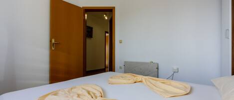 Ein Hotelzimmer mit einem Bett, einer Holztür und einem Marmorkopfende.