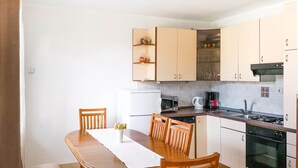 A compact kitchen with a dining table, chairs, a microwave, a coffee maker, and a stove. - Apartment Donna (Biograd)