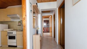 Una cucina con mobili in legno, un piano cottura bianco e un pavimento piastrellato.