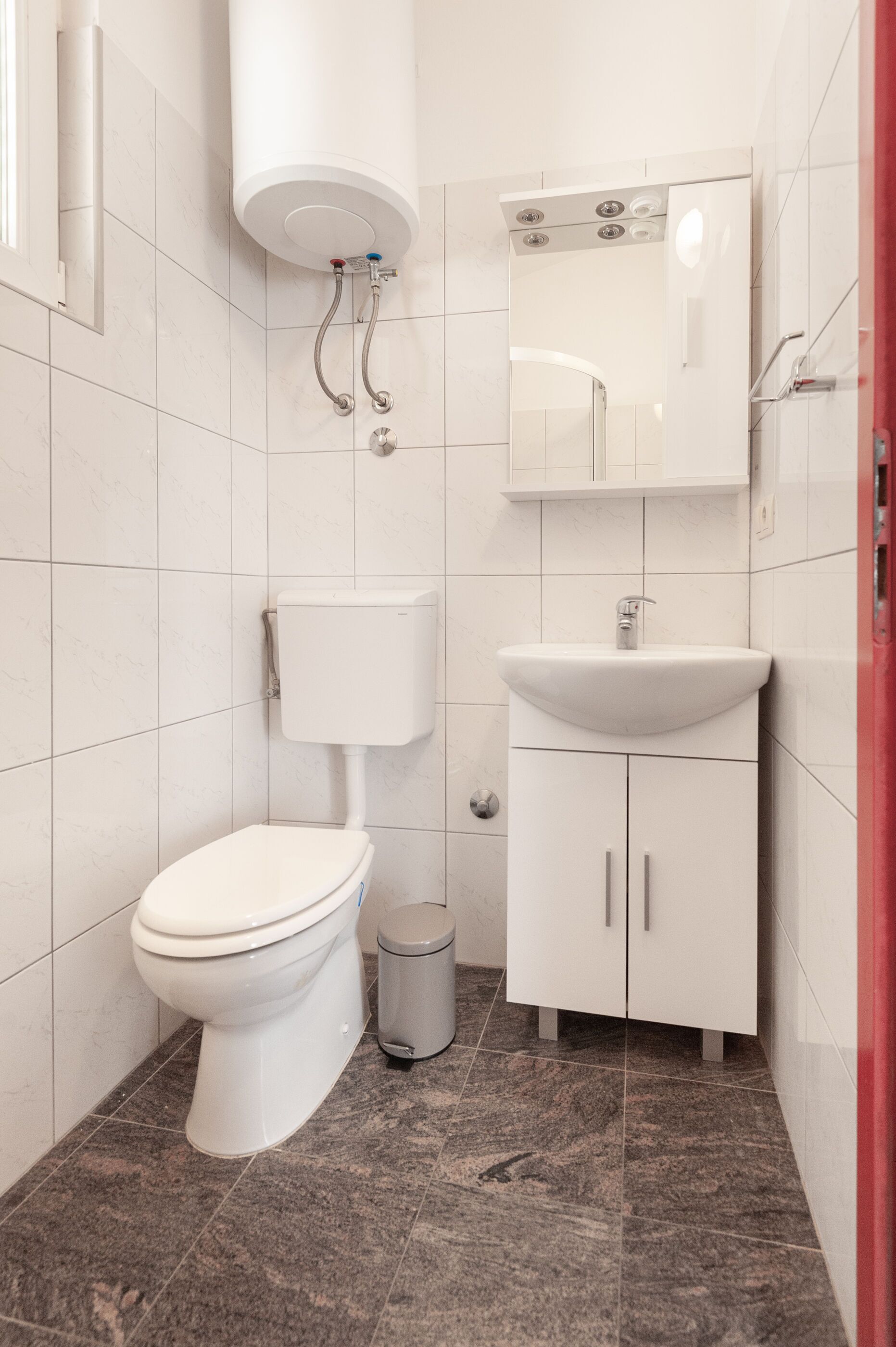 Ein Badezimmer mit Toilette, Waschbecken und Spiegel.