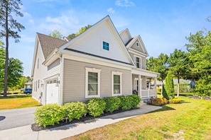 A two-story house with a front porch, a garage, and a well-maintained lawn.