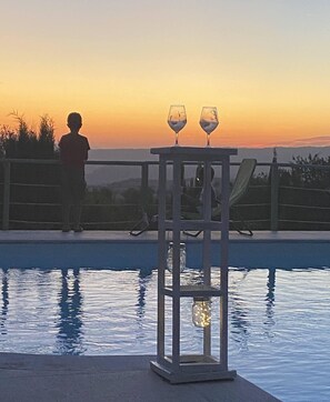 A poolside view with a railing, two glasses on a table, and a person standing. - Apartment/ flat - Montemerano (Montemerano)