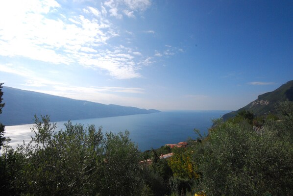 Un paysage côtier offrant une vue sur la mer et les montagnes lointaines.
