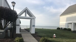 A gated entrance to a building with a view of the sea, a mailbox, and a fire hydrant. - Waterfront home;heated pool & spa: walk to public beach; food, bars, live music! (Port Clinton)