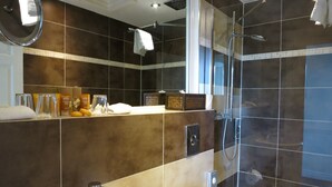 Un baño moderno con un espejo grande, un lavamanos y una zona de ducha.