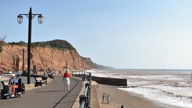 A coastal promenade with benches, a paved walkway, and a cliffside. - 4 bedroom accommodation in Sidmouth (Sidmouth)