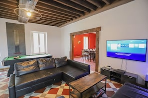 Una televisión, una chimenea, videojuegos, un futbolín