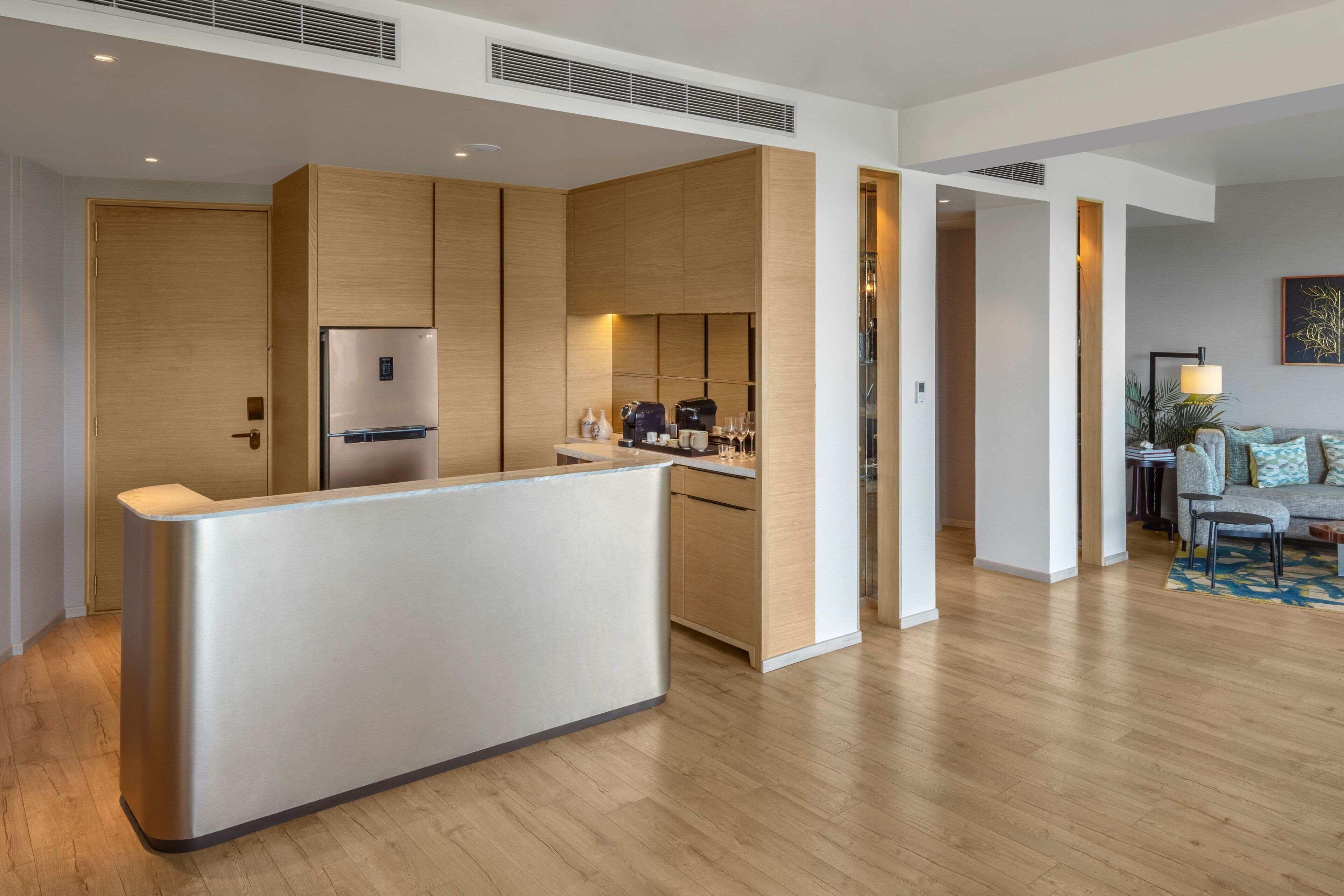 Una cocina moderna con una isla central, electrodomésticos integrados y un rincón comedor con sofá y mesa de centro.
