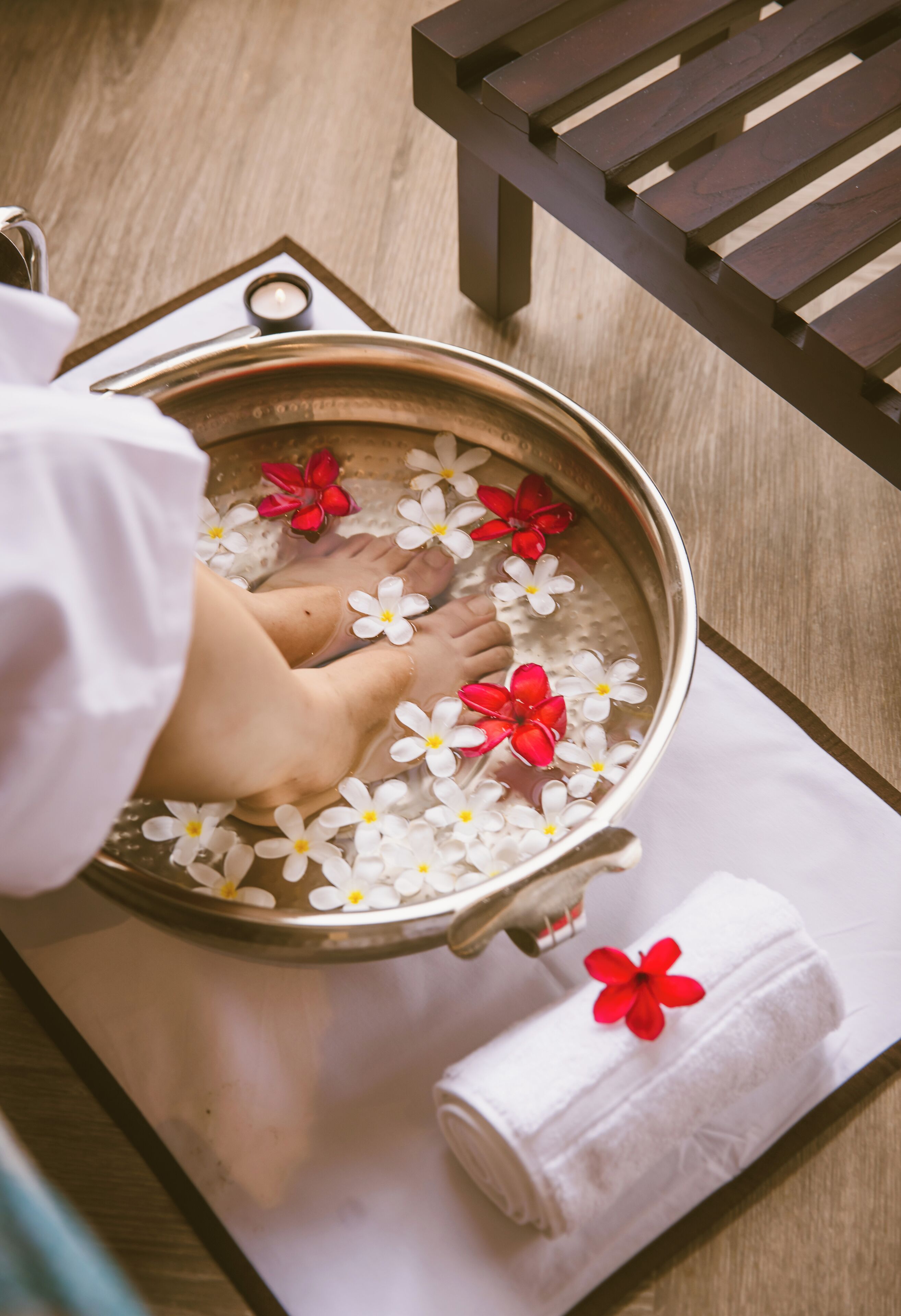 A foot soak with flowers and a candle.