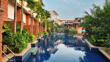 Una piscina al aire libre, sombrillas, sillones reclinables de piscina