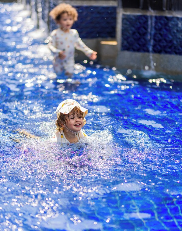 A child playing in a pool with water splashing around. - The Westin Goa (Anjuna)