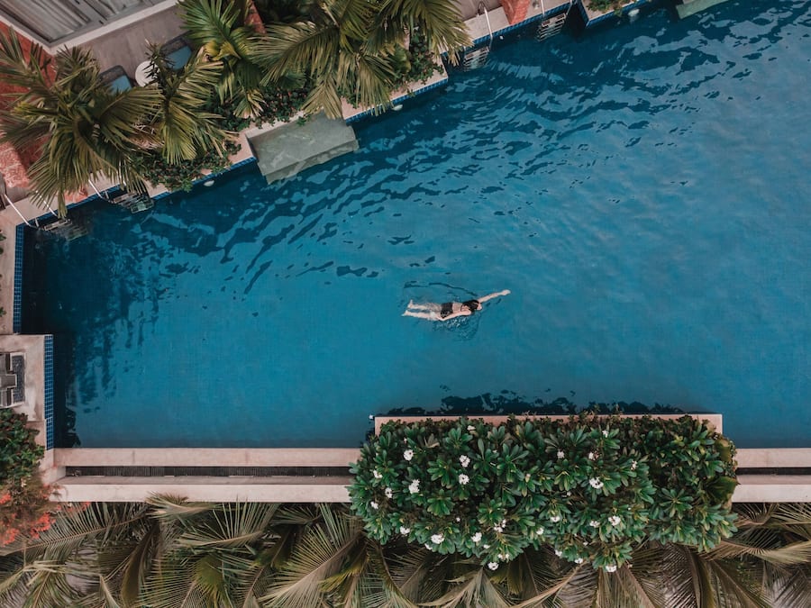 Una piscina al aire libre, sombrillas, sillones reclinables de piscina