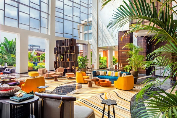 Un hall espacioso con muebles modernos, ventanas amplias y plantas de interior.