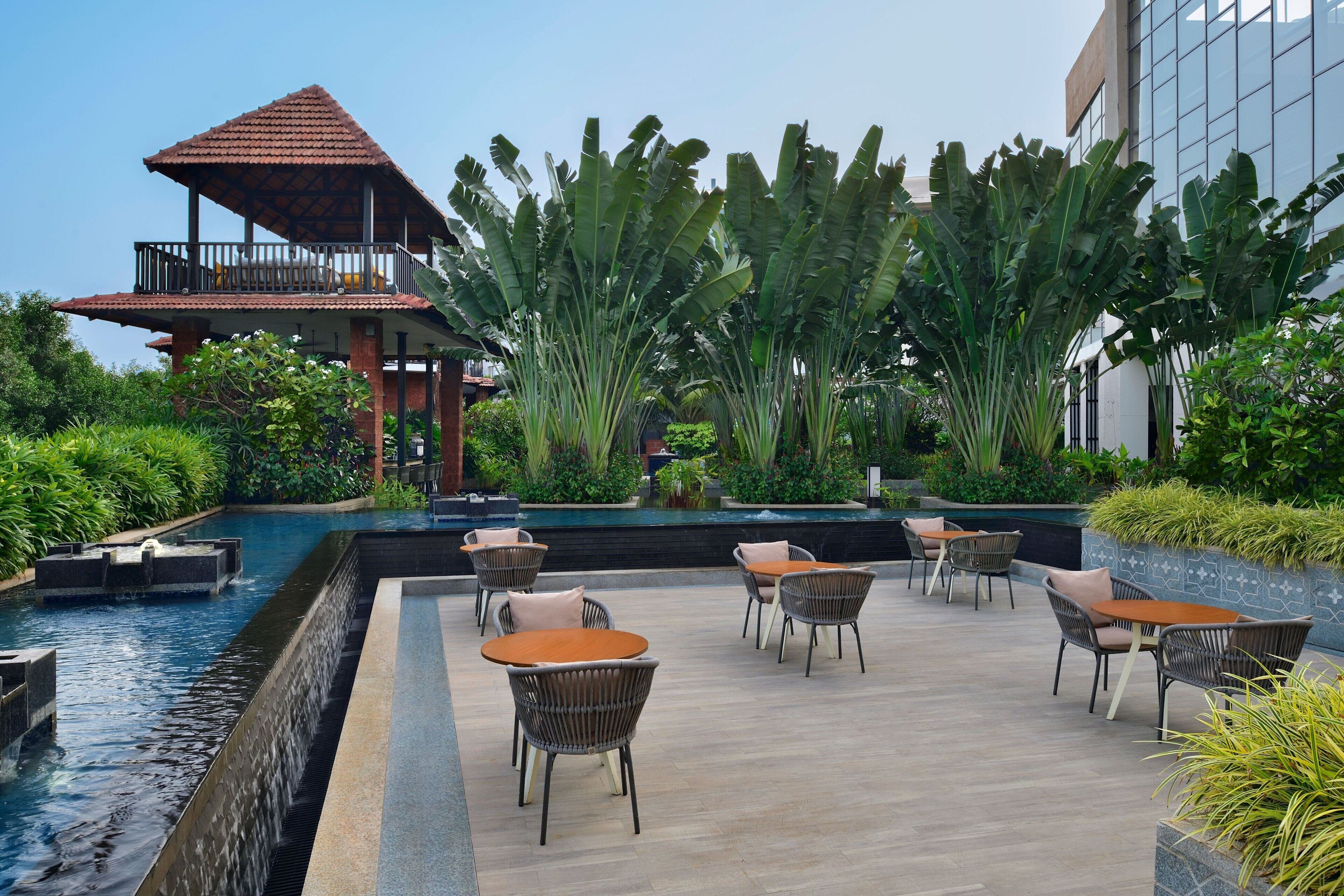 A serene outdoor area with a pool, lounge chairs, and a gazebo.