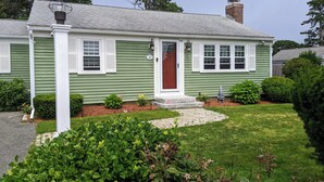 A single-story house with a green exterior, white trim, and a red front door. - Walk to the beach- Completely renovated 3 bedrooms house, central A/C (Dennis)