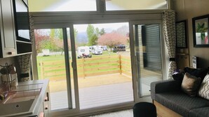 A modern living room with a large sliding glass door leading to a covered outdoor area. - 2 Bed Lodge - Sleeps 4 - Pets - Hot Tub - Parking (Inverness)