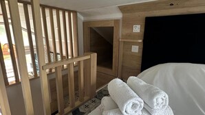 A hotel room with a bed, a wooden partition, a small door, and a tiled floor. - 2 Bed Lodge - Sleeps 4 - Pets - Hot Tub - Parking (Inverness)