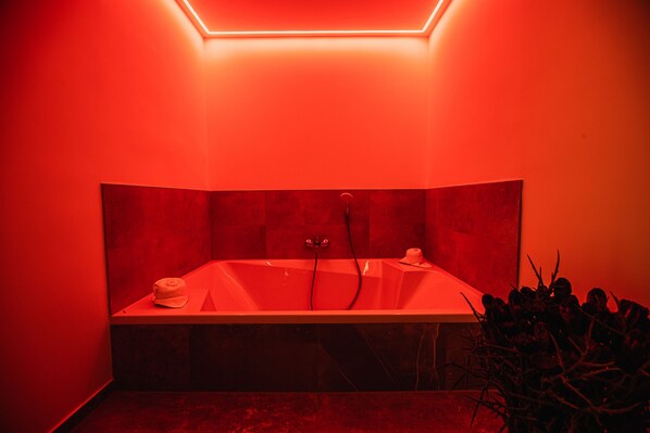 A modern bathroom with a freestanding bathtub, a towel, and a plant.