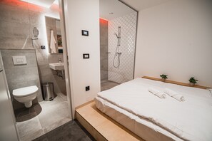 A modern bathroom with a toilet, sink, and shower.