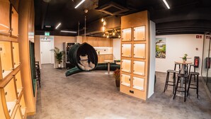 Ein modernes Interieur mit einem Hängekorbstuhl, Holzschränken und einem Feuerlöscher an der Wand.