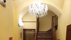 Una escalera con barandilla de madera que conduce a un ascensor.