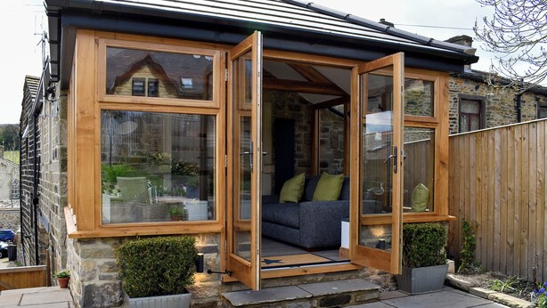 A cozy cottage with a wooden exterior, large glass windows, and a stone foundation. - 2 bedroom accommodation in Addingham, near Ilkley (Addingham, near Ilkley)