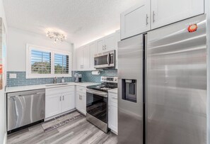 Enjoy cooking in this well-equipped kitchen with a refrigerator, microwave, and dishwasher, and take in the view from the large window.