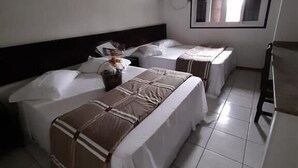 A hotel room with two beds, a small table, and a window. - Partner Hotéis by Holz (Joinville)
