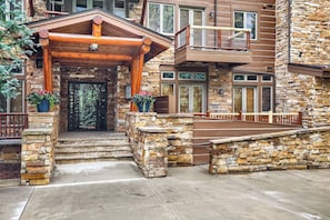 A stone building with a wooden entrance, a balcony, and a stone staircase leading to the entrance.