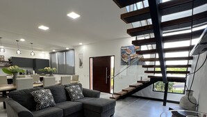 Una sala moderna con un sofá modular, una mesa de centro de madera y una mesita auxiliar con cubierta de vidrio.