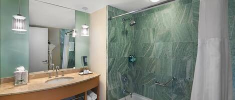 A modern bathroom with a double sink vanity, a bathtub, and a shower with a glass door.