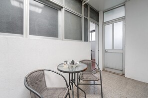 Enjoy a peaceful retreat on this balcony with a round table and two chairs.