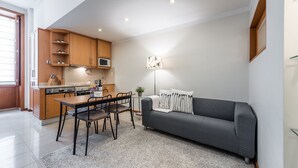 A compact living space with a kitchenette, a dining area, and a sofa.
