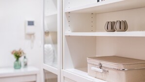 A white storage box with a zipper on a white shelf.