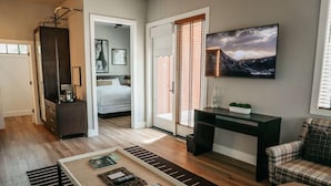 Une chambre d’hôtel moderne équipée d’un lit, d’un bureau, d’une télévision et offrant une vue sur l’extérieur.