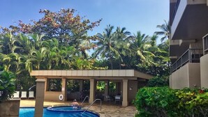 A swimming pool with a stone deck, surrounded by palm trees and a covered seating area. - Ext Maint Special up to 50% disc Ocean Sunset Vw! (Lahaina)