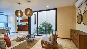 Un salon moderne avec un canapé, une table basse et des luminaires suspendus.