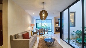 Un salon moderne avec un canapé, une table basse et un coin repas.