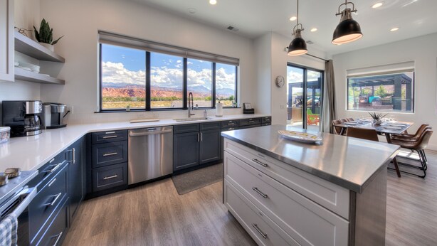 A modern kitchen with a large island, stainless steel appliances, and a view of the mountains. - Luxury twin home.  Beautiful views. Private hot tub. Covered outside patio.  (Moab)