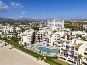 Un complexe hôtelier comprenant plusieurs bâtiments, une piscine et une plage.