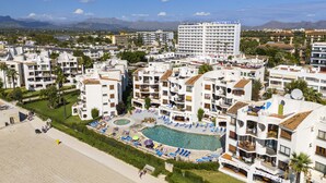 A hotel complex with multiple buildings, a swimming pool, and a beach area. - Apartamento Carabela 51 (Puerto de Alcudia)