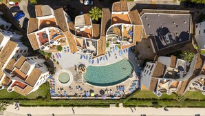 An aerial view of a resort with multiple swimming pools, sun loungers, and a beach area. - Apartamento Carabela 51 (Puerto de Alcudia)