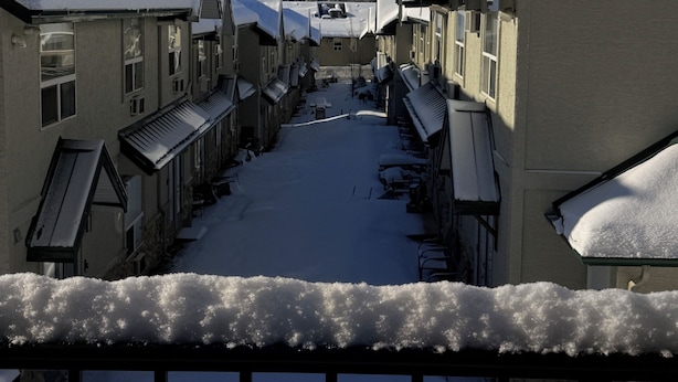 Un pueblo cubierto de nieve con edificios tradicionales y una montaña al fondo.
