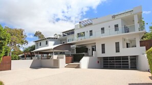 A modern multi-story house with a covered driveway, a garage, and a balcony.