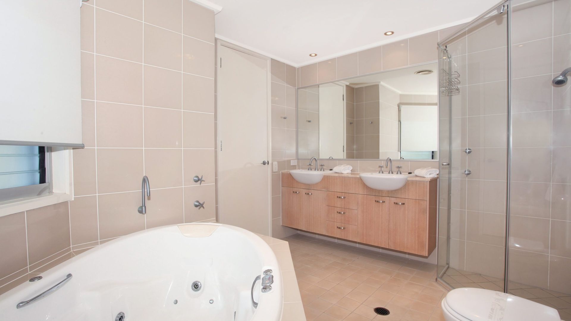 A modern bathroom with a freestanding bathtub, a double sink vanity, and a glass-enclosed shower.
