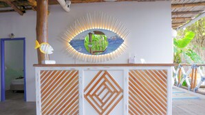 Una recepció amb un mirall decoratiu, disseny de panells de fusta i vistes a l'exterior.