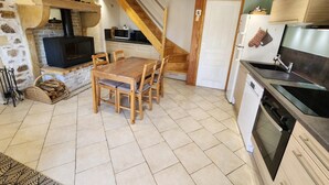 A kitchen with a wooden table, a built-in stove, a microwave, and a dishwasher. - Chez la Lise - TANCON (TANCON)